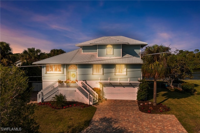 3968 Aloha Ln, Bonita Springs, FL 34134 - view of front of house with stairs, an attached garage, decorative driveway, a front yard, and a metal roof
