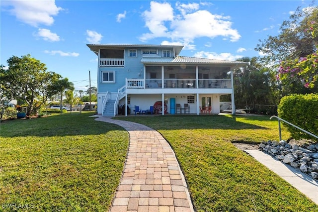 back of house with a yard and a sunroom