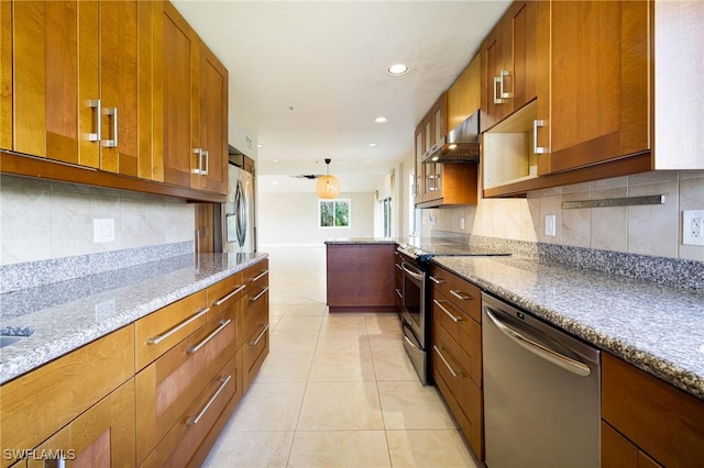 3968 Aloha Ln, Bonita Springs, FL 34134 - kitchen with appliances with stainless steel finishes, wall chimney range hood, brown cabinetry, light tile patterned floors, and recessed lighting