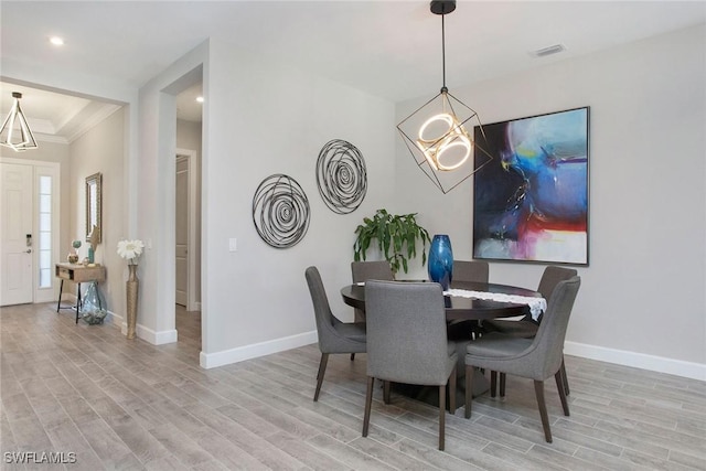 dining area featuring visible vents, baseboards, and wood finished floors