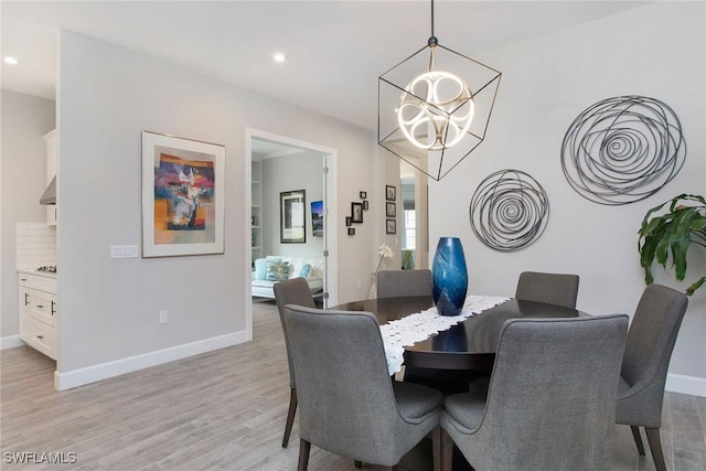 dining room featuring light wood finished floors, recessed lighting, an inviting chandelier, and baseboards