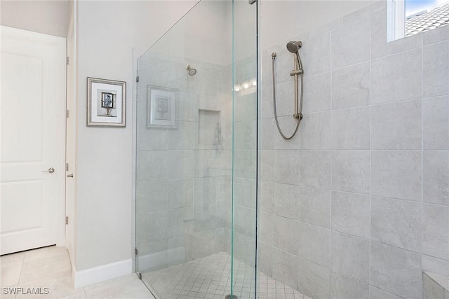 bathroom featuring tile patterned floors, baseboards, and a tile shower