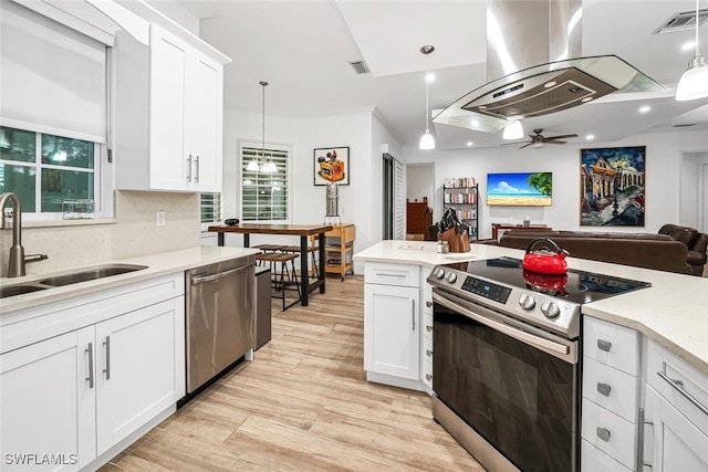 kitchen with island exhaust hood, hanging light fixtures, white cabinets, and stainless steel appliances