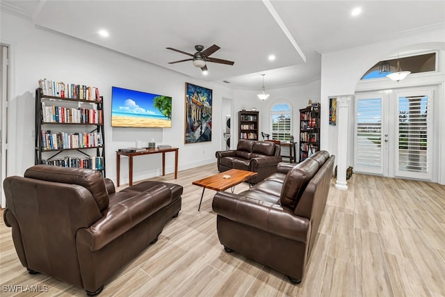 living room featuring ceiling fan with notable chandelier, light hardwood / wood-style floors, ornamental molding, and french doors