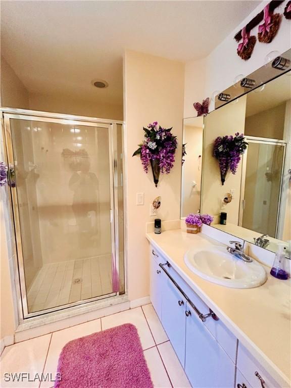 bathroom featuring tile patterned flooring, vanity, and a shower with door