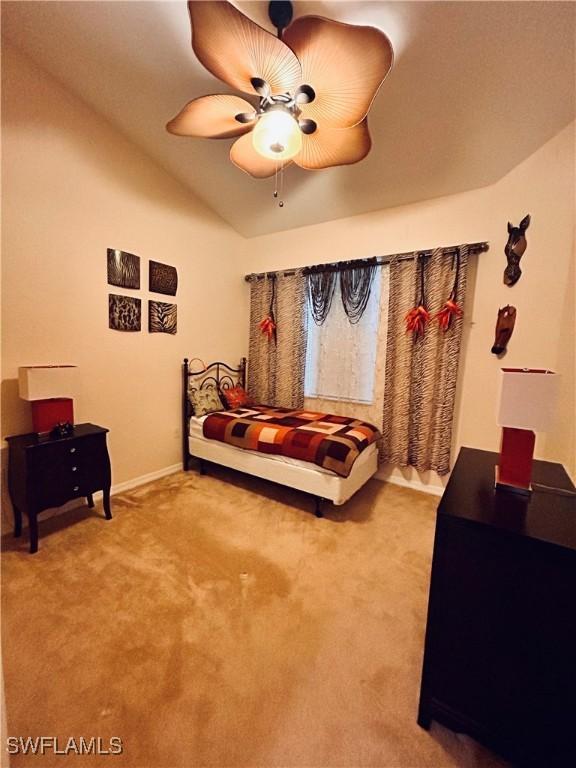 carpeted bedroom with ceiling fan and lofted ceiling