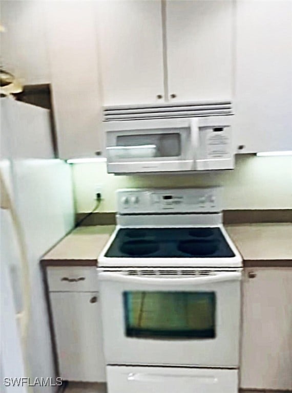 kitchen with white cabinetry and white appliances