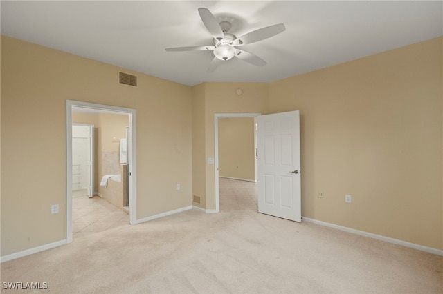 unfurnished bedroom featuring light carpet, ensuite bathroom, and ceiling fan