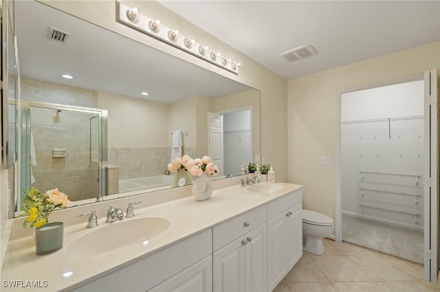 full bathroom with tile patterned flooring, shower with separate bathtub, vanity, and toilet