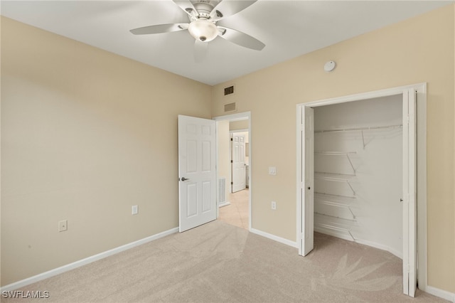 unfurnished bedroom with ceiling fan, light carpet, and a closet