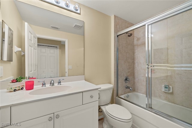 full bathroom featuring bath / shower combo with glass door, vanity, and toilet