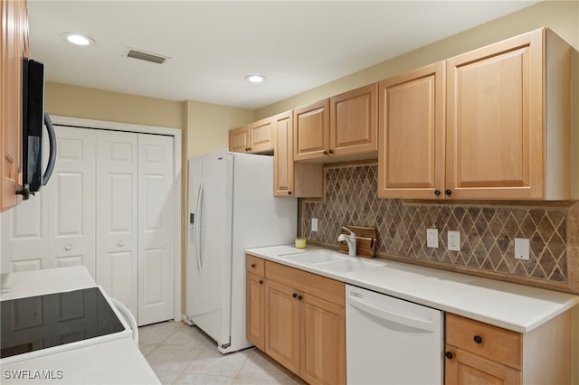 kitchen featuring tasteful backsplash, white appliances, sink, light brown cabinets, and light tile patterned floors