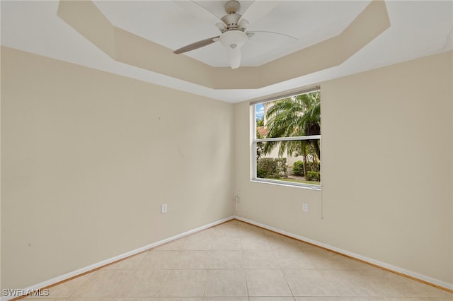 spare room featuring a tray ceiling and ceiling fan