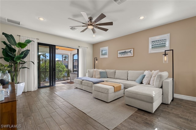 living room with ceiling fan and dark wood-type flooring