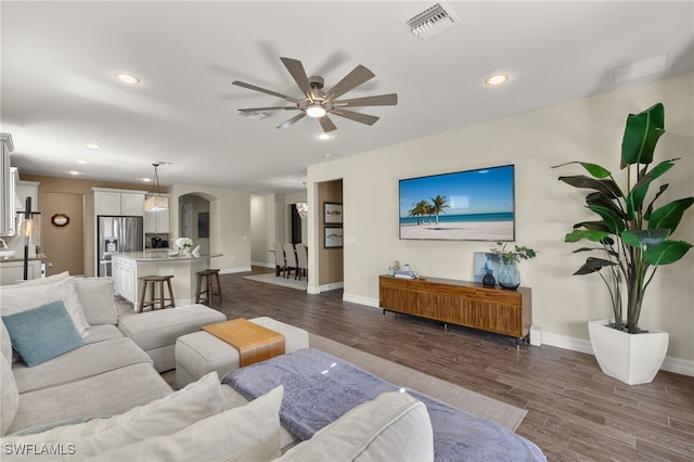 living room featuring dark hardwood / wood-style floors and ceiling fan