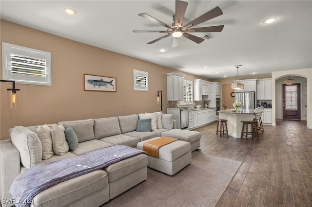 living room featuring dark hardwood / wood-style flooring, ceiling fan, and sink