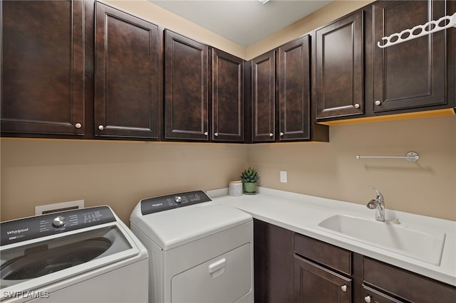 clothes washing area with washer and dryer, cabinets, and sink