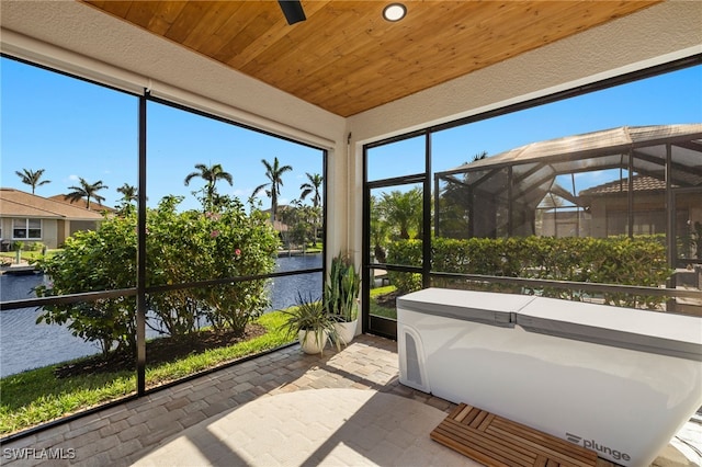 sunroom / solarium featuring a water view and wood ceiling