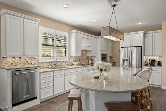 kitchen with white cabinetry, sink, hanging light fixtures, and appliances with stainless steel finishes