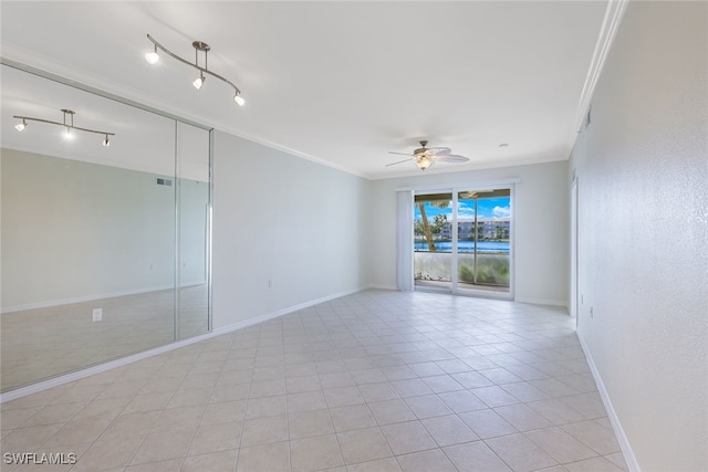 empty room with crown molding, ceiling fan, and light tile patterned floors