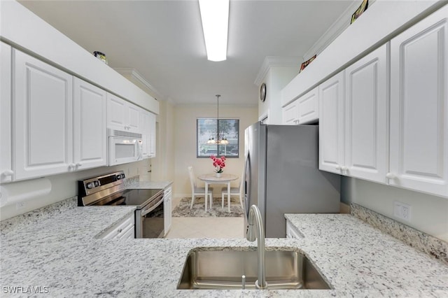 16635 Lake Circle Dr Unit 614, Fort Myers, FL 33908 - kitchen with appliances with stainless steel finishes, a sink, white cabinetry, crown molding, and pendant lighting