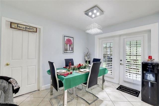 dining space with a chandelier, french doors, and light tile patterned floors