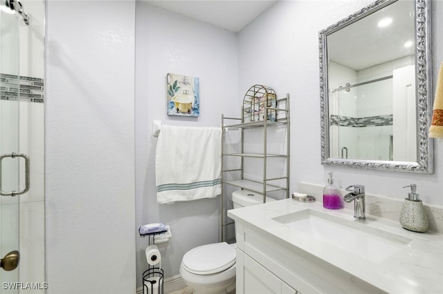 bathroom featuring vanity, toilet, and a shower with door