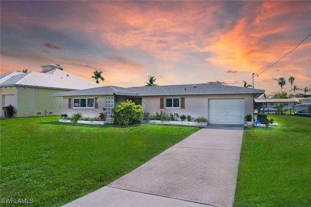 single story home featuring a lawn and a garage