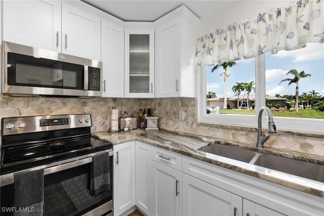 kitchen featuring decorative backsplash, sink, white cabinets, and stainless steel appliances