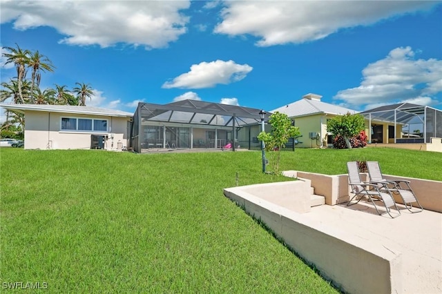 back of property with glass enclosure, a patio area, and a yard