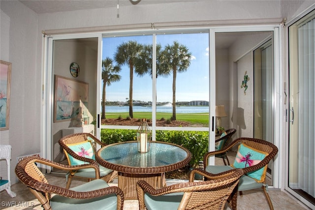 sunroom / solarium featuring a water view