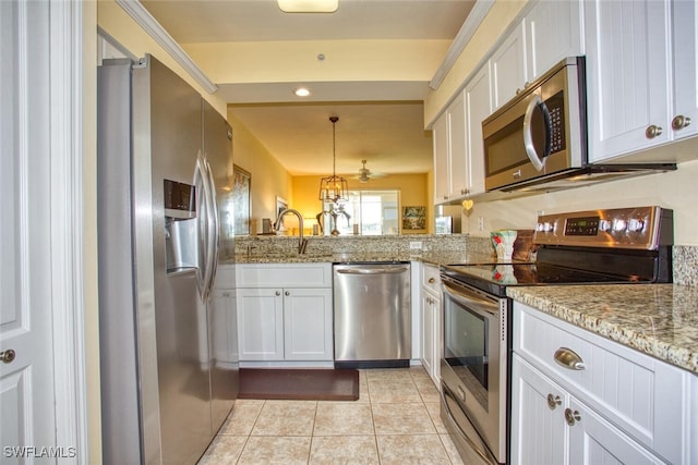 kitchen featuring kitchen peninsula, appliances with stainless steel finishes, decorative light fixtures, light stone counters, and white cabinetry