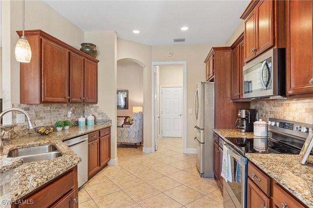 kitchen featuring decorative backsplash, sink, hanging light fixtures, and appliances with stainless steel finishes