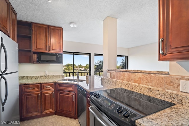 kitchen featuring light stone countertops, a textured ceiling, stainless steel appliances, sink, and light tile patterned flooring