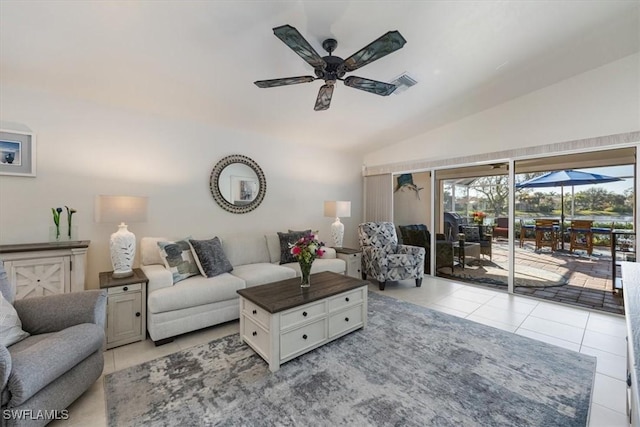 tiled living room featuring ceiling fan and vaulted ceiling