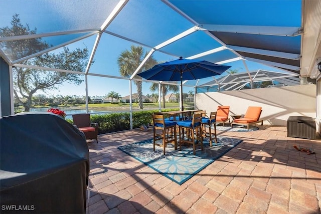 view of patio / terrace with a lanai, a grill, and a water view