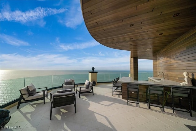 view of patio / terrace with a water view and a bar