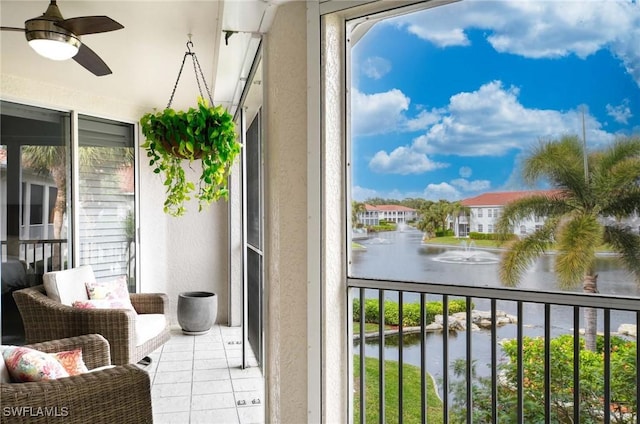 balcony featuring ceiling fan and a water view