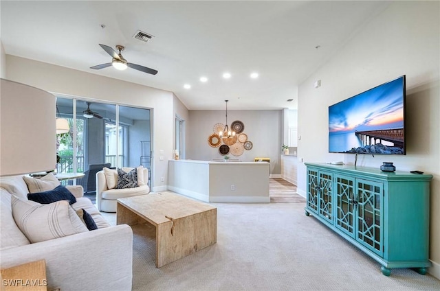 living room with light colored carpet and ceiling fan with notable chandelier