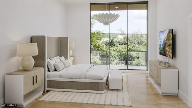 bedroom with a notable chandelier, light hardwood / wood-style floors, and a wall of windows