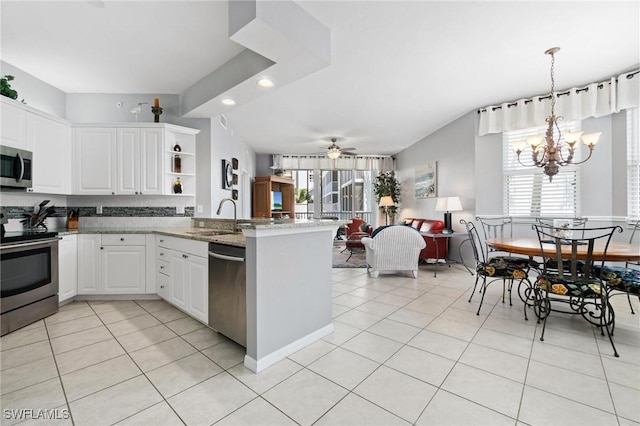 kitchen with white cabinets, ceiling fan with notable chandelier, kitchen peninsula, and appliances with stainless steel finishes