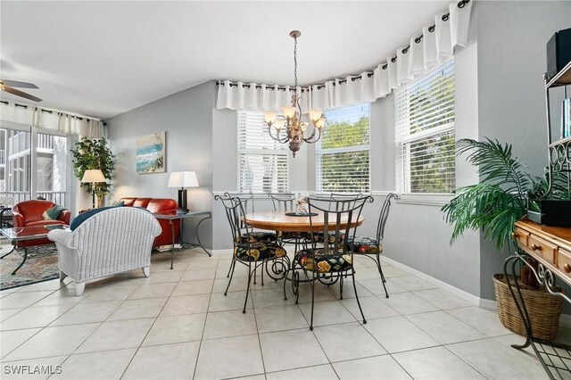 dining room with light tile patterned floors and ceiling fan with notable chandelier