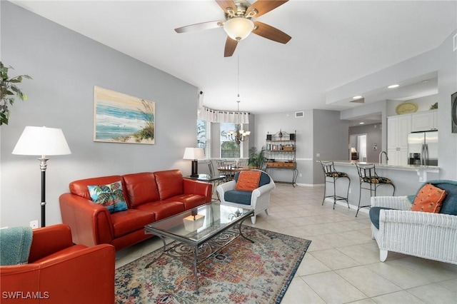 tiled living room featuring ceiling fan with notable chandelier