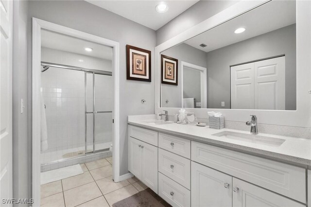 bathroom with tile patterned flooring, vanity, and a shower with shower door