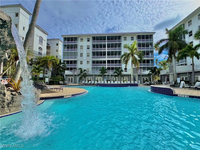 view of swimming pool with pool water feature and a patio area