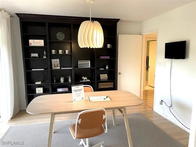 office area with hardwood / wood-style flooring and built in shelves