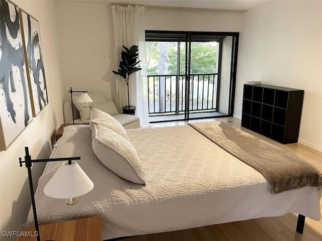 bedroom with access to exterior and light wood-type flooring