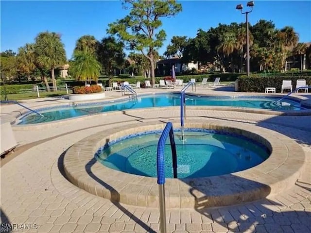 view of swimming pool featuring a hot tub