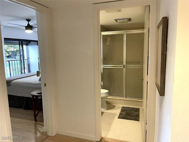 bathroom featuring hardwood / wood-style floors, toilet, an enclosed shower, and ceiling fan