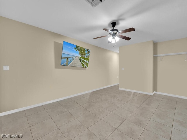 empty room with light tile patterned floors and ceiling fan